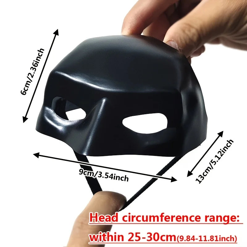 A black bat wing cat mask is shown with measurements and a hand demonstrating its fit.