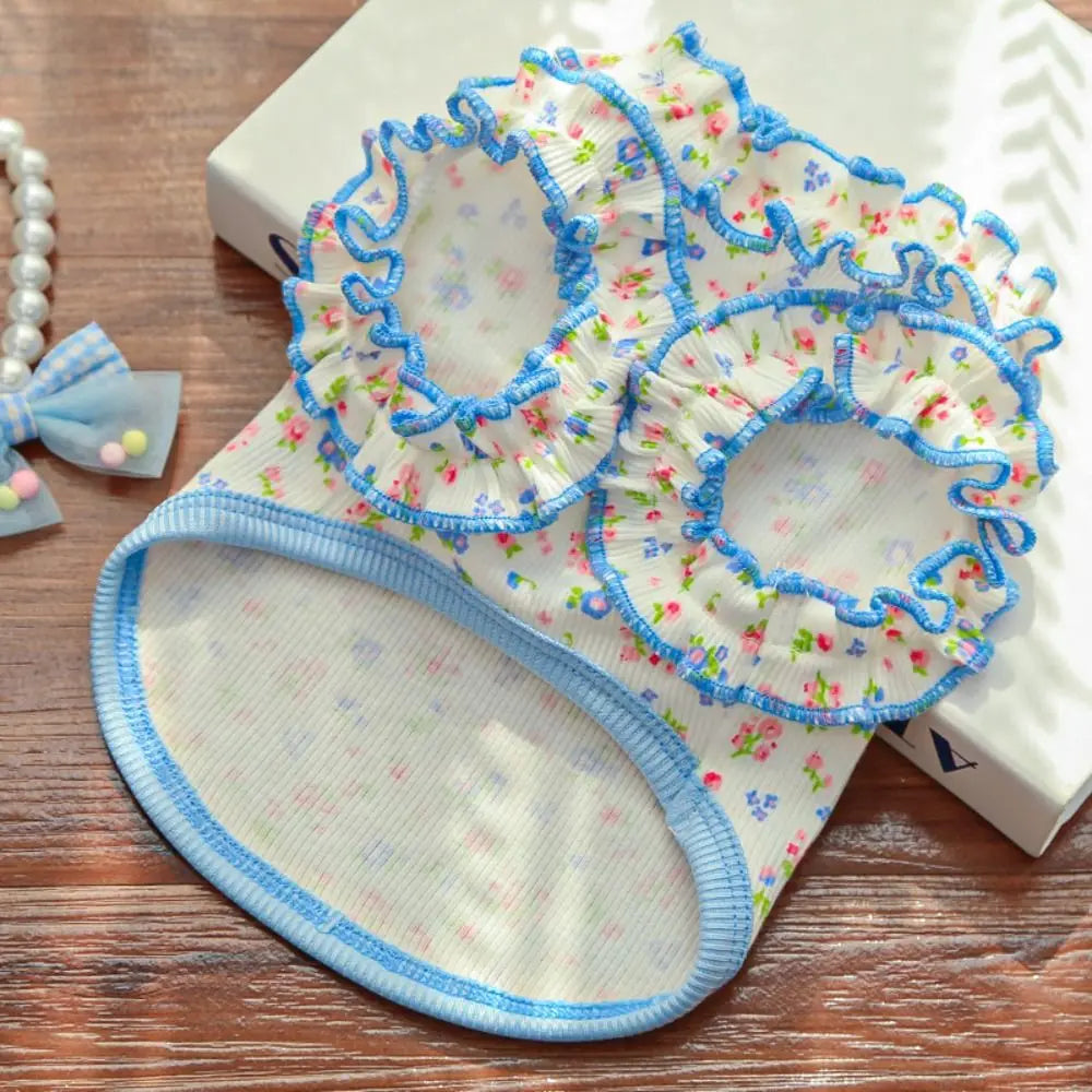 A light blue floral vest for dogs and cats with ruffled trim and a matching fabric bottom.