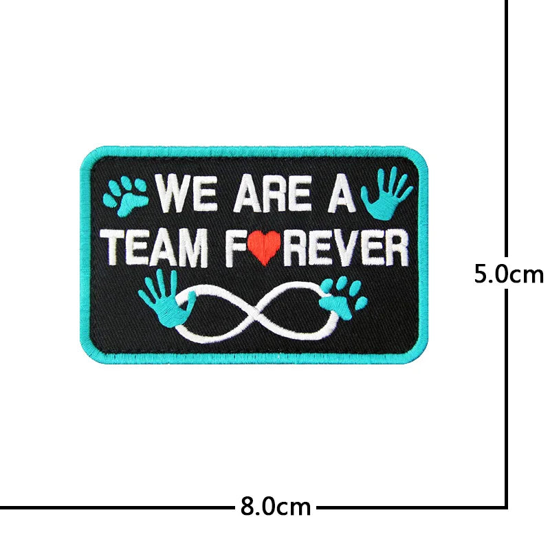 Black embroidered patch with teal text and paw prints, featuring a heart and infinity symbol.