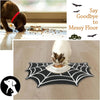 Halloween pet feeding mat with a black spider web design placed on a light wooden floor.