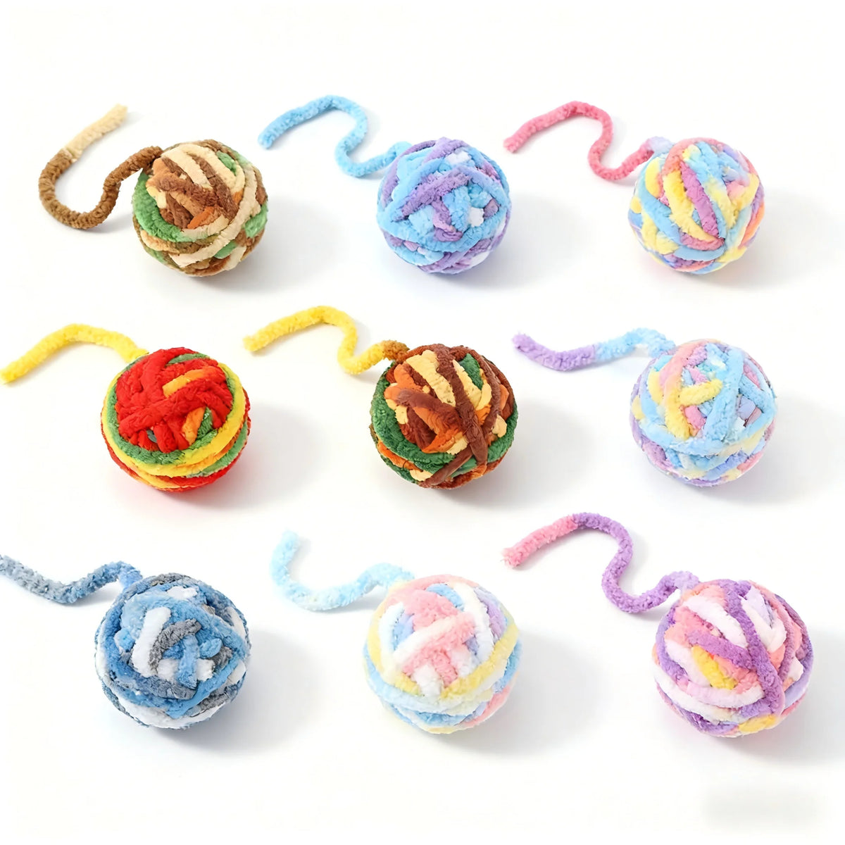 A collection of colorful, fuzzy plush cat toys shaped like balls with dangling tails.