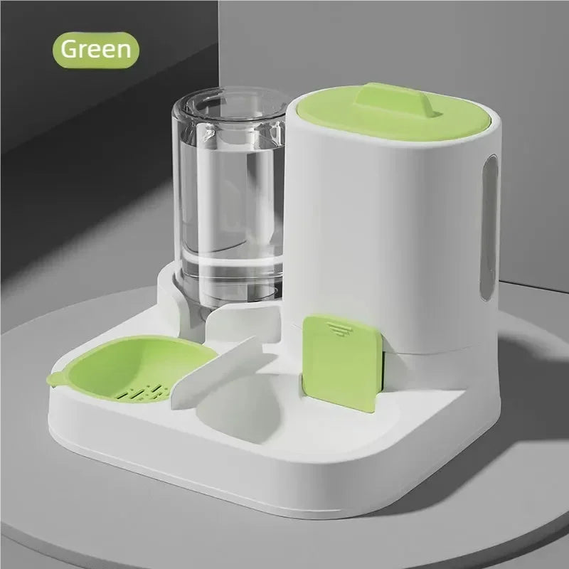 A white gravity water dispenser for pets with a green lid and feeding tray, shown on a gray surface.