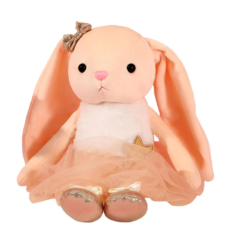 A soft peach colored plush rabbit toy with large ears and a sheer pink tutu skirt.