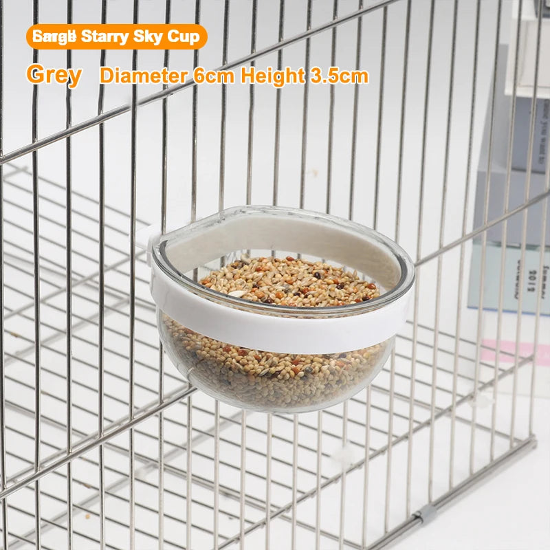 Grey Starry Sky Cup bird feeder with a transparent window hanging in a wire mesh cage