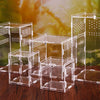 A collection of clear acrylic reptile terrariums displayed on a wooden surface.