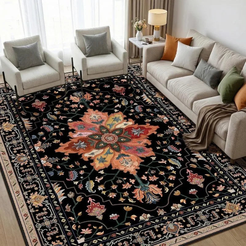 A dark floral Persian area rug with intricate patterns in shades of orange, rust, and green in a living room setting.