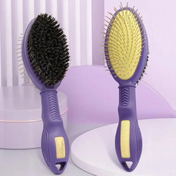A pair of purple double-sided pet grooming brushes with black and yellow bristles are displayed on a white surface.