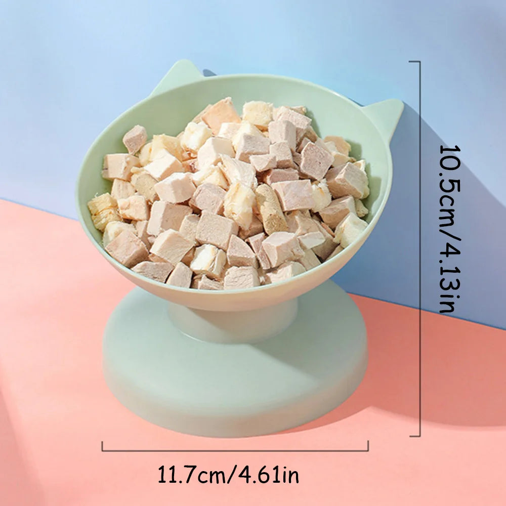 A light green pet food and water bowl with a non-slip base, filled with cubed pet food.