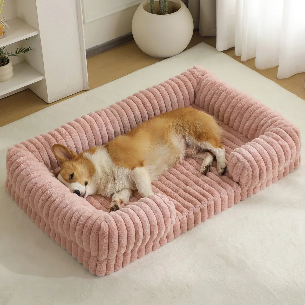 Ein flauschiger orange-weißer Hund entspannt sich in einem rosa, gerippten Winterhundbett auf einer weißen Oberfläche.