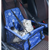 A gray tabby cat is sitting inside a blue pet travel booster seat with a safety belt, placed in a car seat.