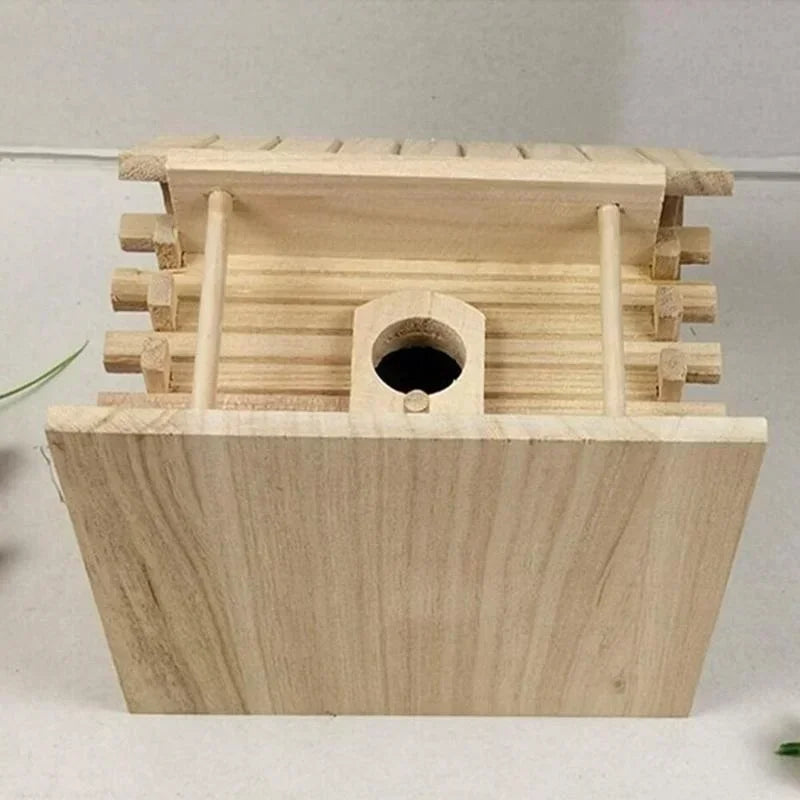 A natural light wood birdhouse made from Paulownia wood with a slatted roof and a circular entrance hole.