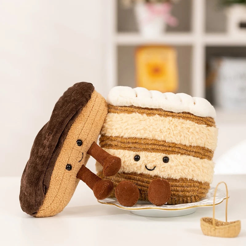 A plush toy shaped like a layered dessert, featuring brown and beige stripes and white frosting.