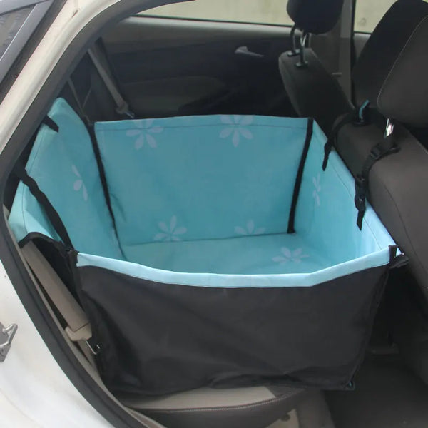 A pet car seat hammock cover in light blue and black fabric is shown inside a car door.