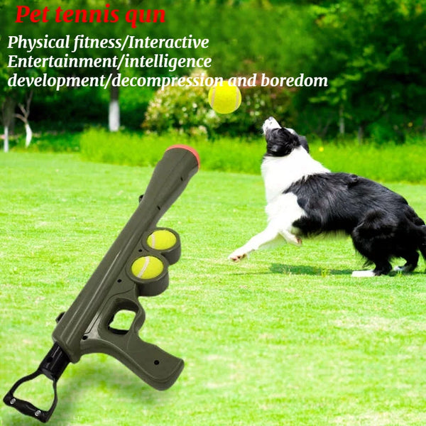 A green dog is playing with a tennis ball launched from a brown dog ball launcher on a grassy field.