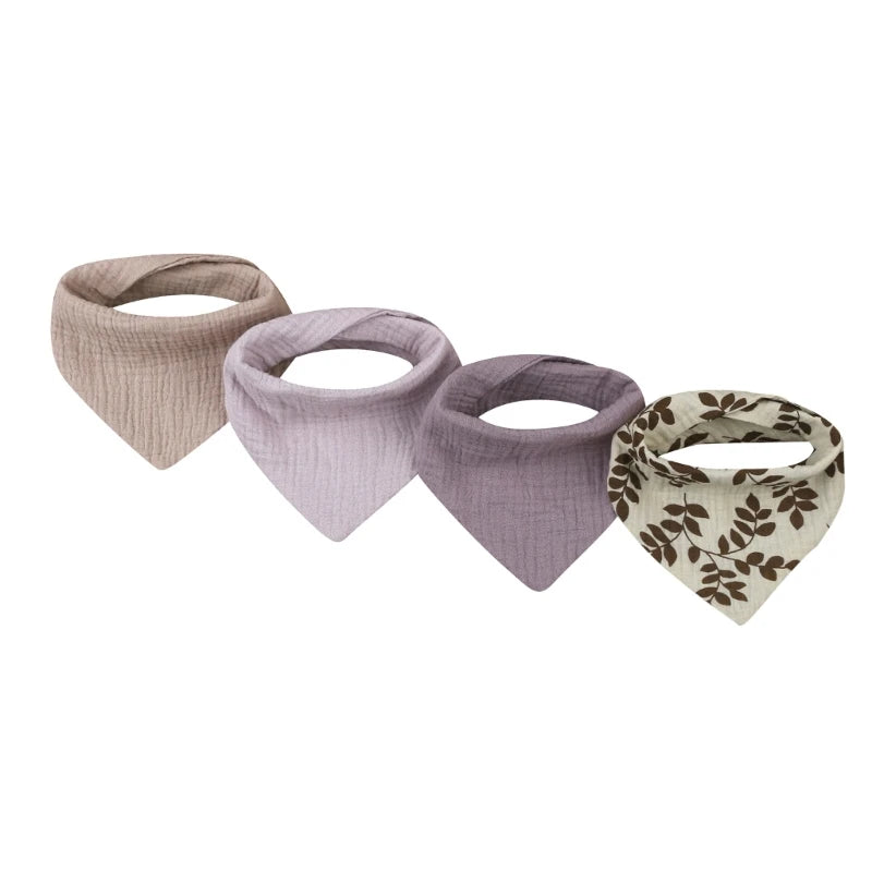 A set of four cotton baby bibs with printed designs for newborns in neutral and floral patterns.