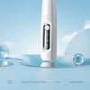 A white portable dog grooming trimmer is shown reflecting on a glass surface with a light blue background.