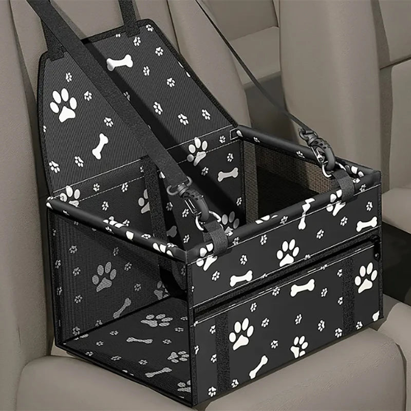 Black pet travel booster seat with a safety belt for dogs and cats shown in a vehicle seat.