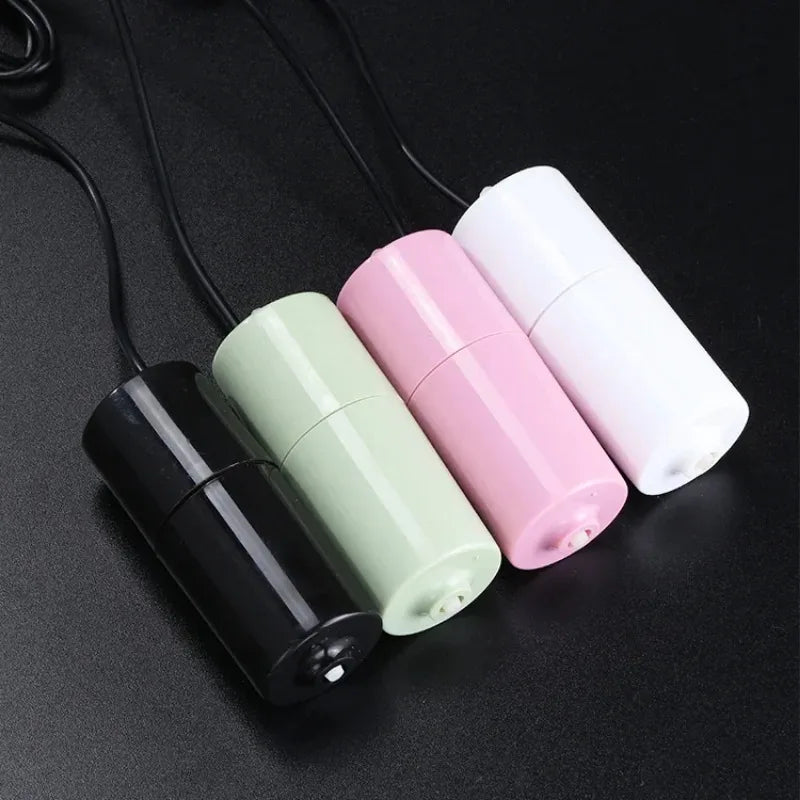 Three white and pink cylindrical air pumps with black wires are displayed on a dark surface.