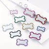 A collection of personalized engraved pet ID tags in various shapes and colors for dog and cat collars.