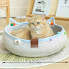 A fluffy orange tabby cat is relaxing in a woven cat scratcher and comfort bed filled with play balls.