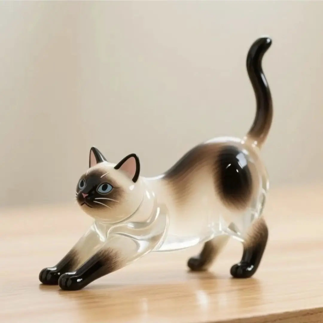 Petite figurine brillante d'un chat en pleine course, avec des marques brunes et noires.