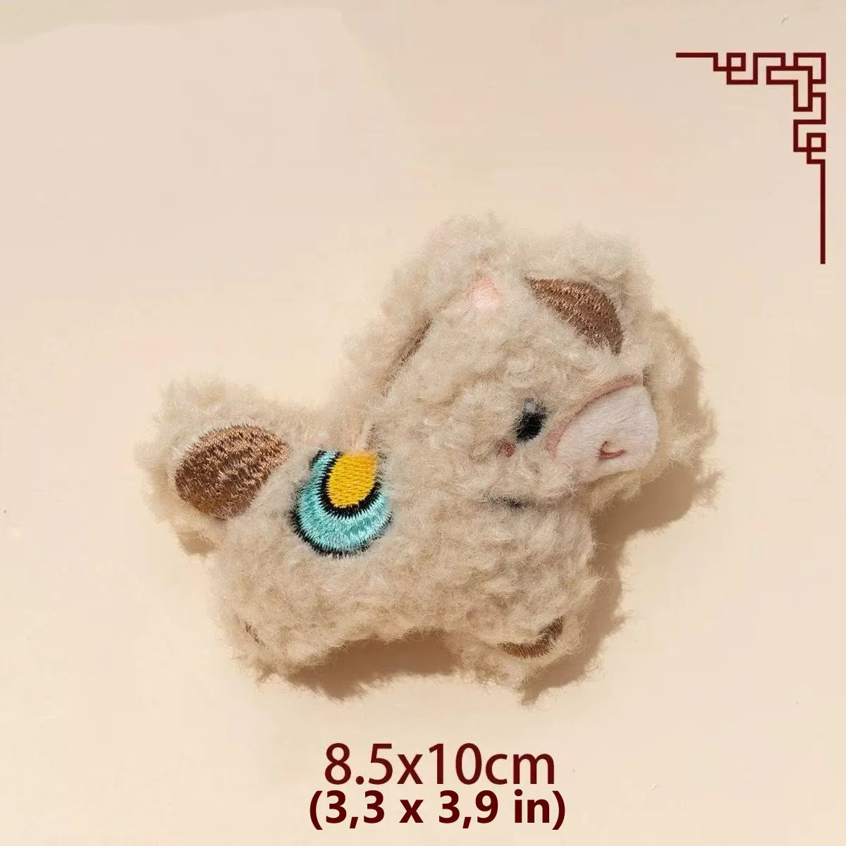 A light beige fluffy plush toy shaped like a dog with brown ears and a blue and yellow accent.