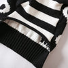 A close-up of a black and white striped knitted pet sweater for cats and small dogs.