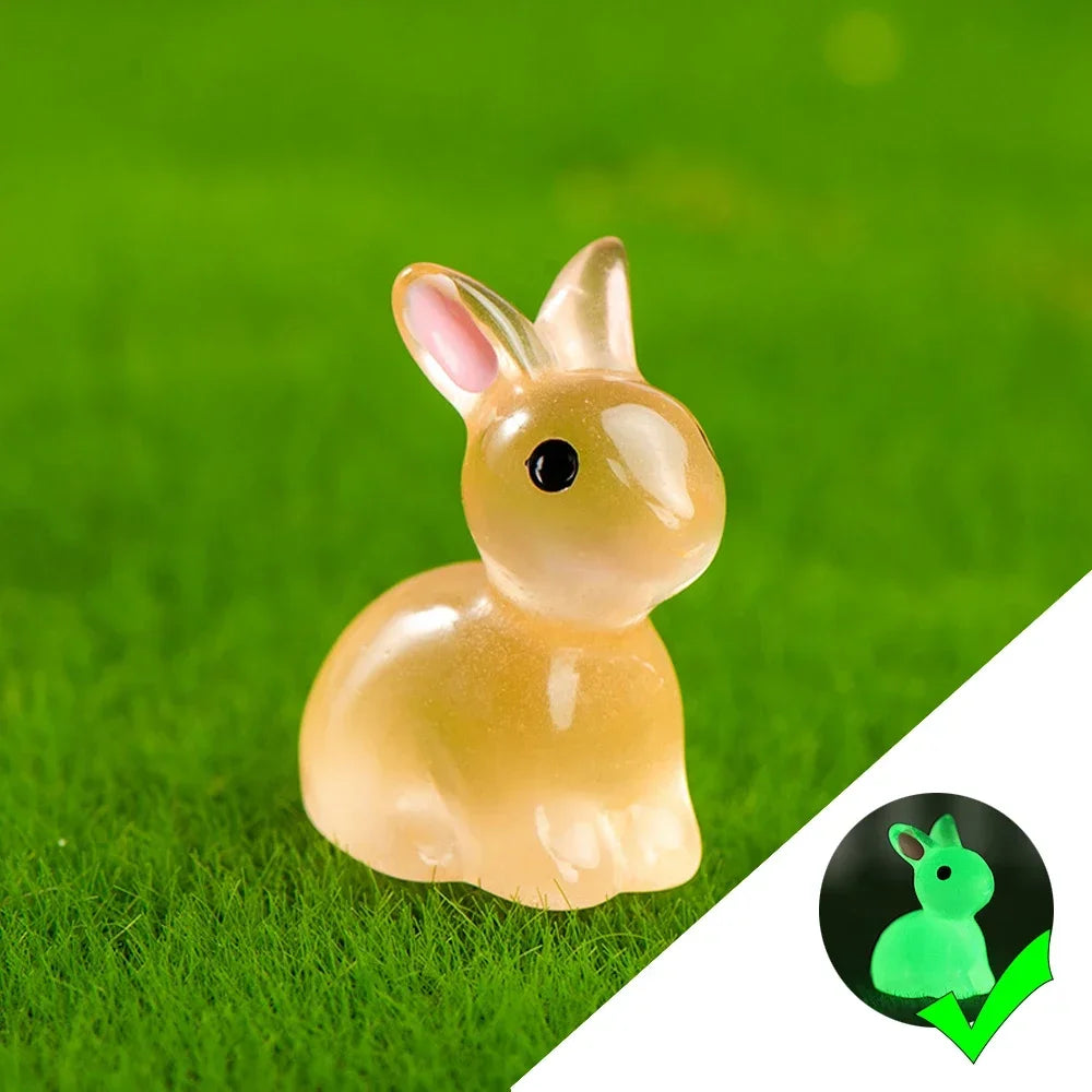 A small, translucent yellow glow-in-the-dark resin bunny figurine sitting on bright green grass.