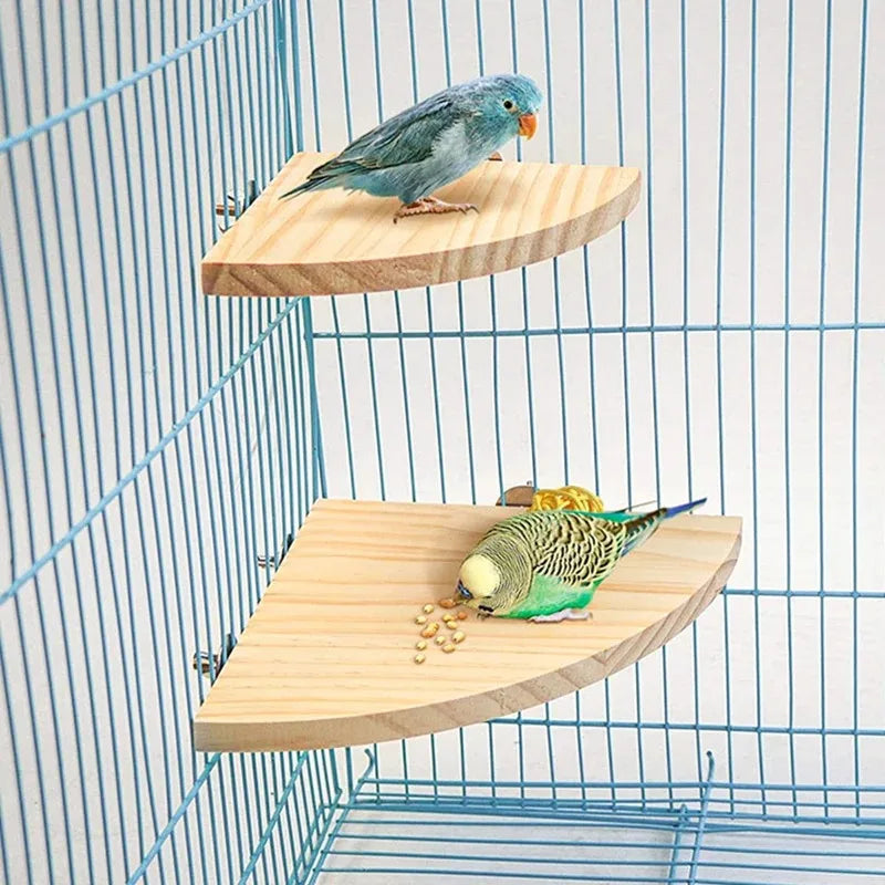 A blue parrot sits on a natural wood perch stand inside a wire cage.