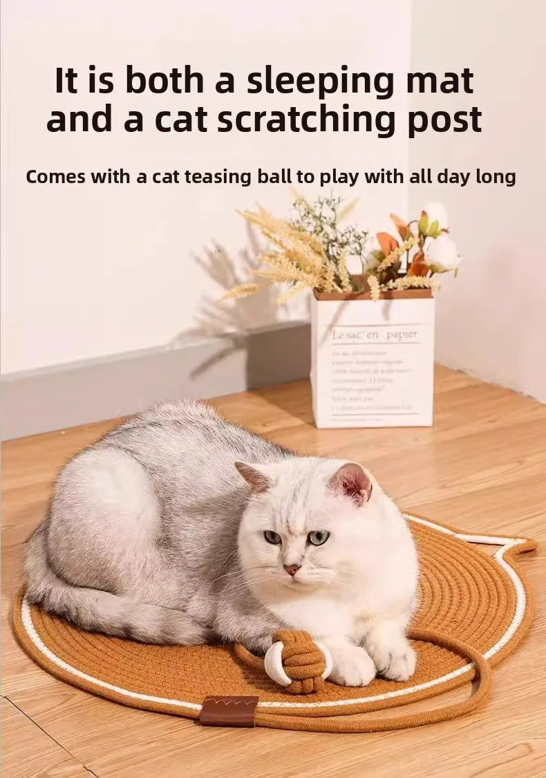 A fluffy gray and white cat is relaxing on a round scratching mat with a small ball.