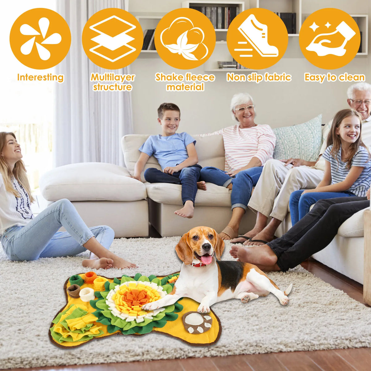 A dog lies on a yellow snuffle mat with treats, while people relax on a sofa in a bright living room.