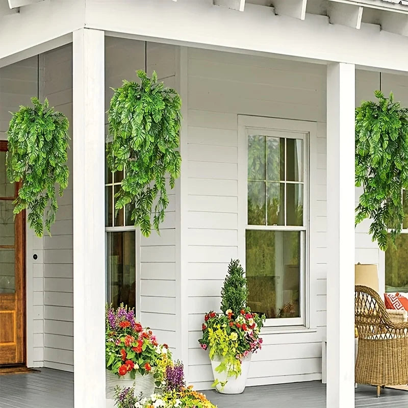 Künstliches Monstera-Blatt-Girlande hängt in einem Fensterrahmen auf einer weißen Veranda