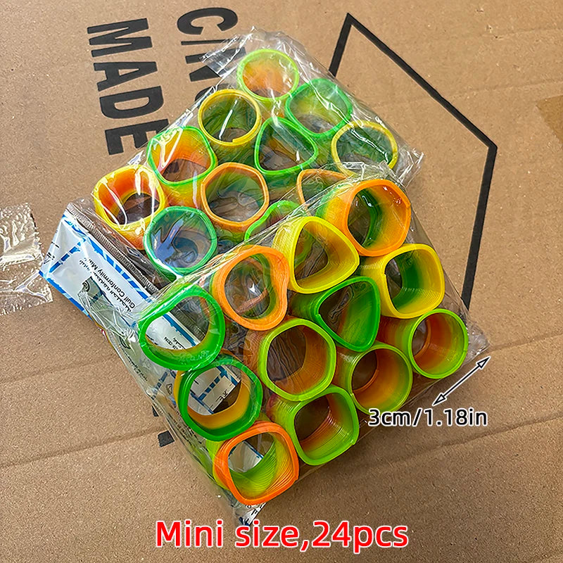 A pile of 24 mini rainbow spring coil toys in various colors like orange, yellow, and green, packaged in clear plastic.