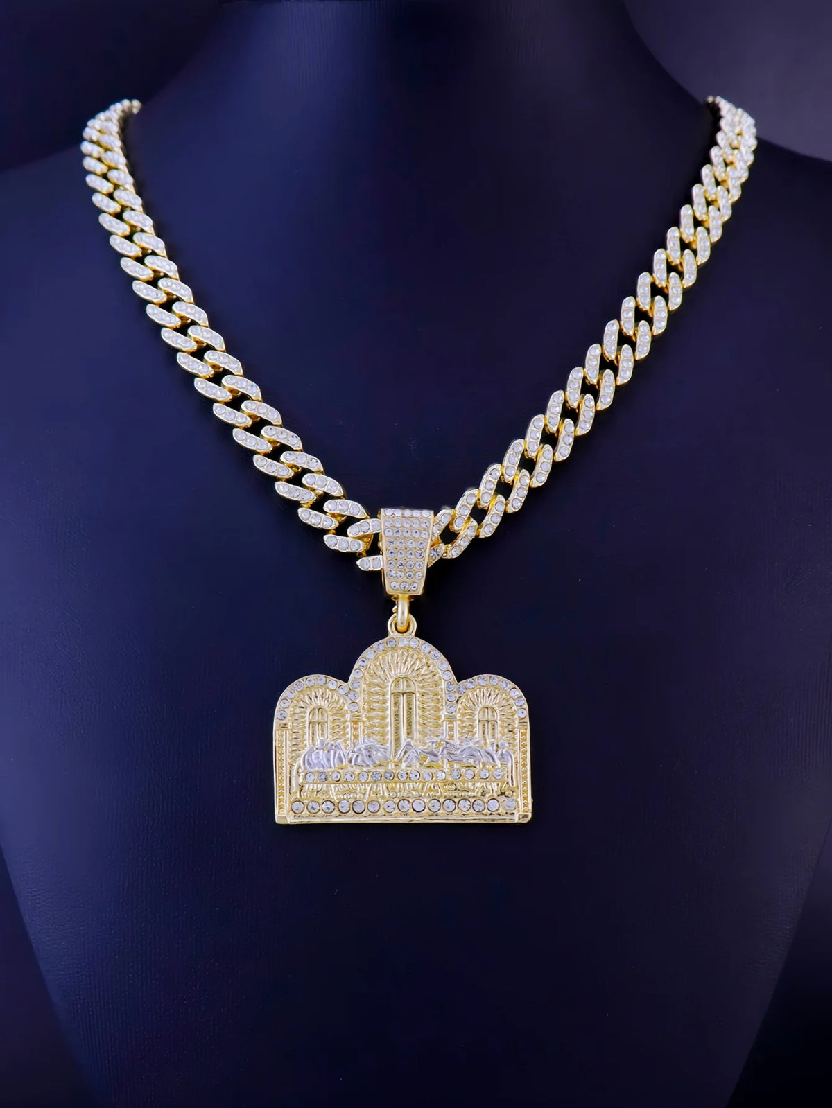 A gold plated last supper medallion necklace featuring a Cuban chain and detailed relief work.