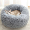 A fluffy gray pet bed with a cat resting inside.