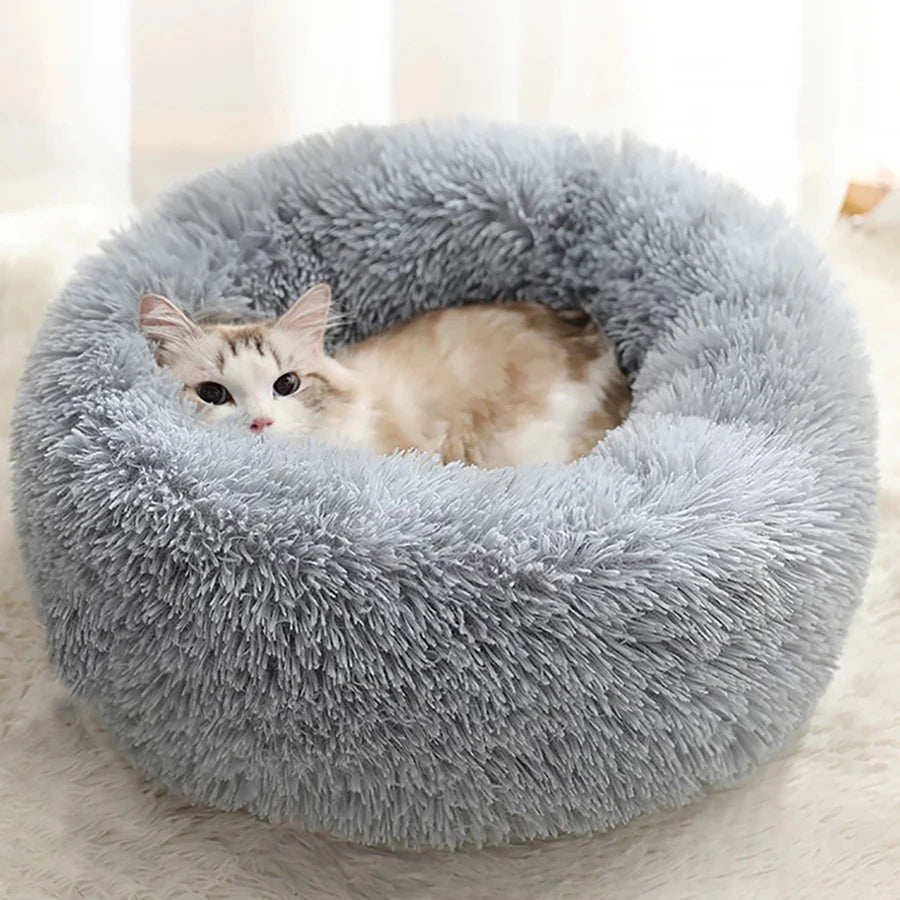 A fluffy gray pet bed with a cat resting inside.