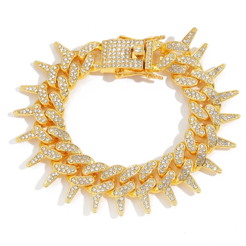 A gold spiked Cuban chain bracelet adorned with diamond accents.