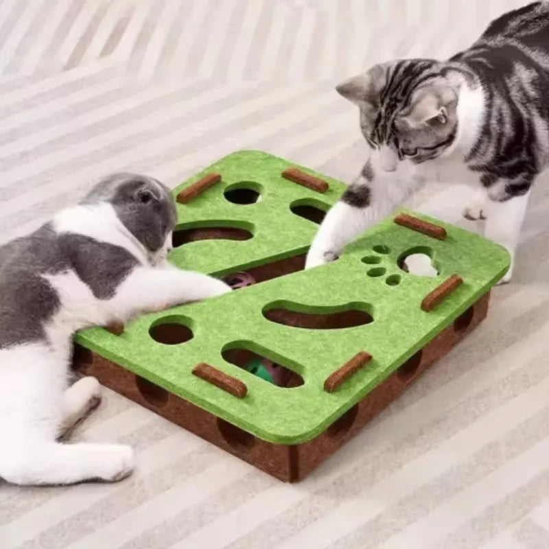 A tabby cat is interacting with a green felt puzzle maze designed for cats.