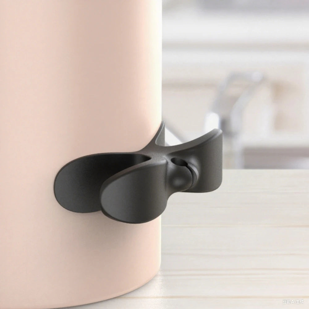 A black silicone cable organizer is attached to a light pink cylindrical object.