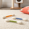 Several oversized cotton swabs with colored tips are displayed on a white textured mat.