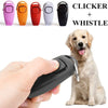 A hand holds a black dog training clicker and whistle set with a golden retriever.