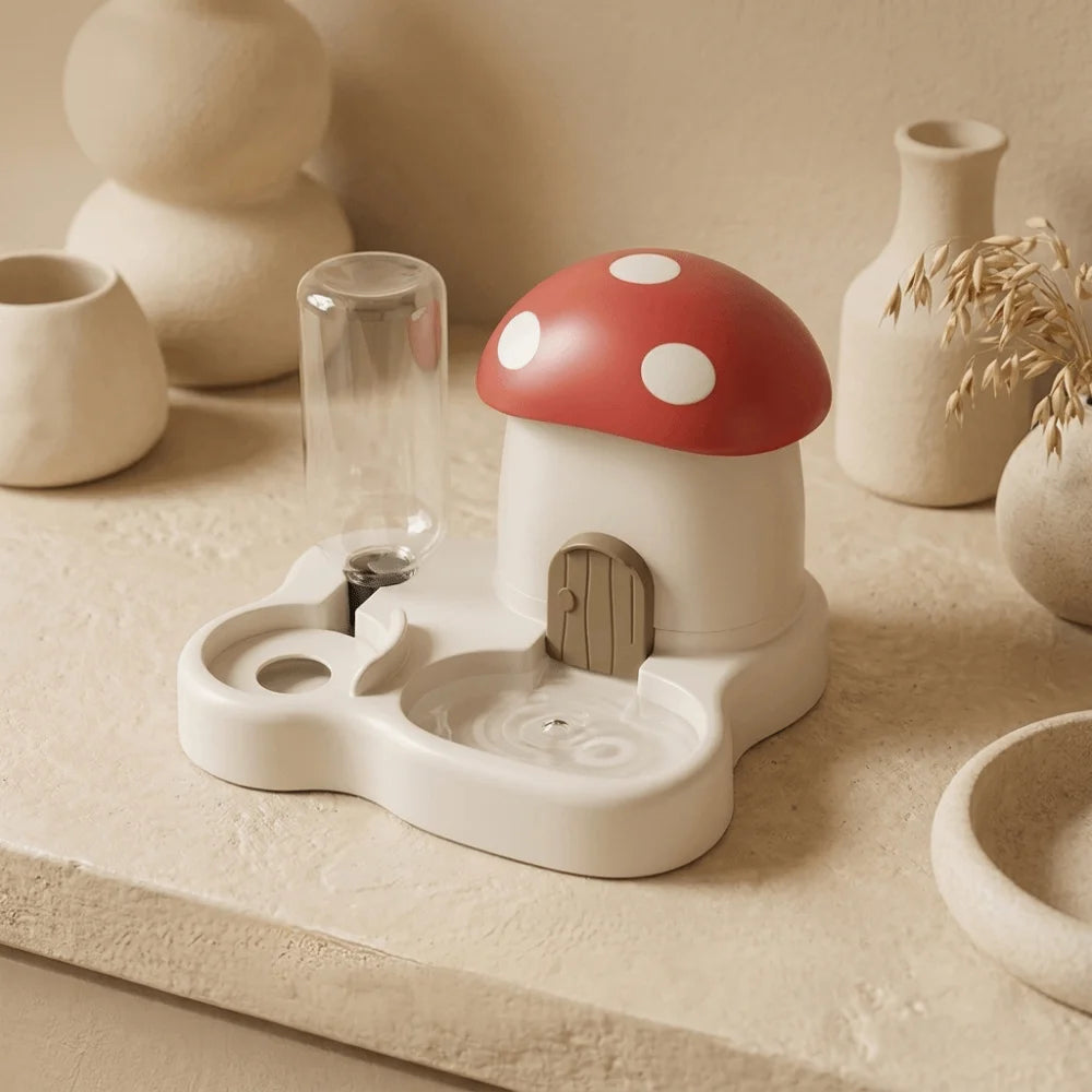A white mushroom-shaped feeder and water dispenser with a red cap and white polka dots sits on a light surface.