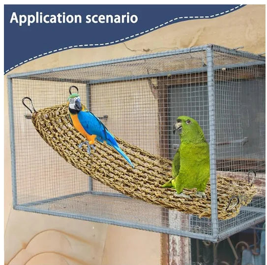 A blue and yellow parrot is perched on a woven hammock inside a wire cage.