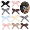 A set of six handmade knitted cotton bows in various colors including black, pink, gray, brown, light blue, cream, and dark g