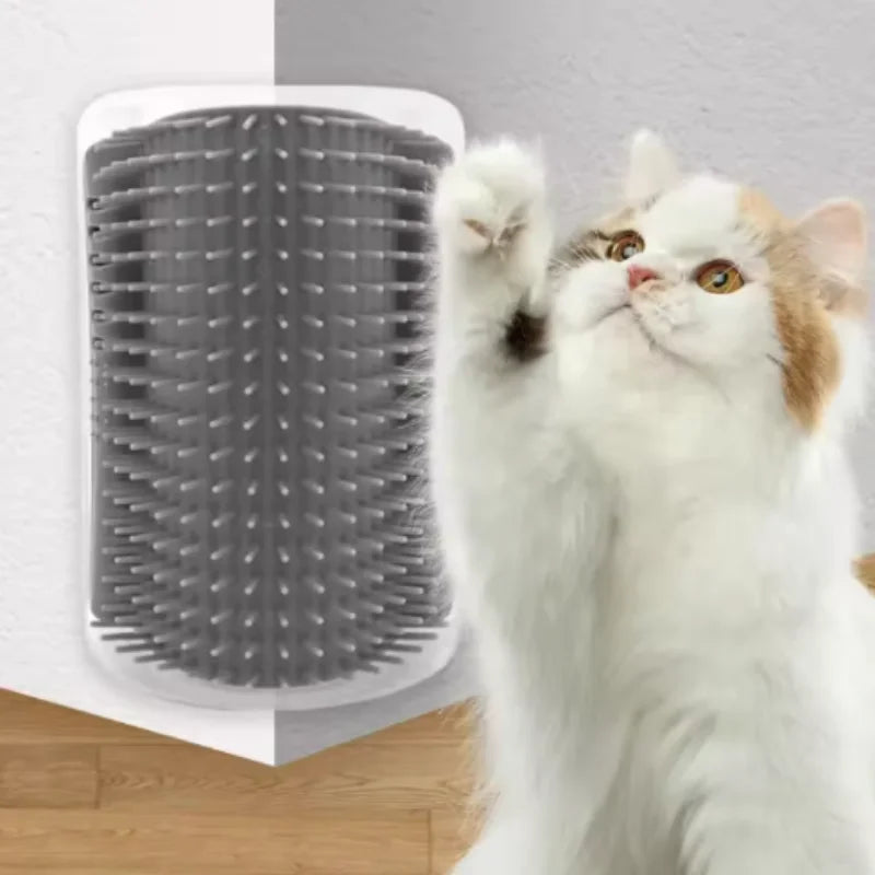 A white cat is using a gray self-grooming brush mounted on a white plastic holder.