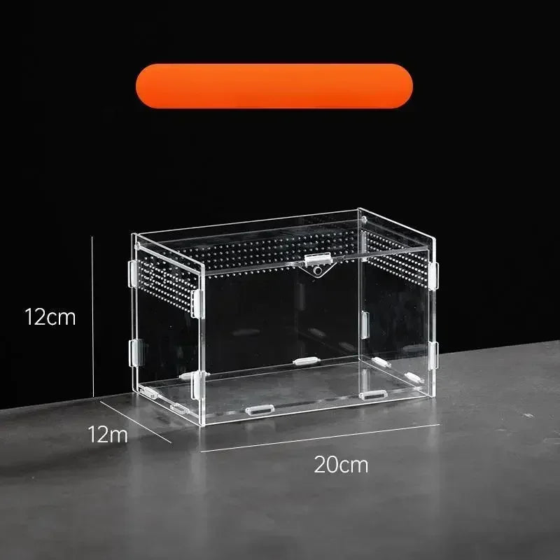 A clear acrylic reptile terrarium box with mesh screening and a black lid shown on a dark surface.
