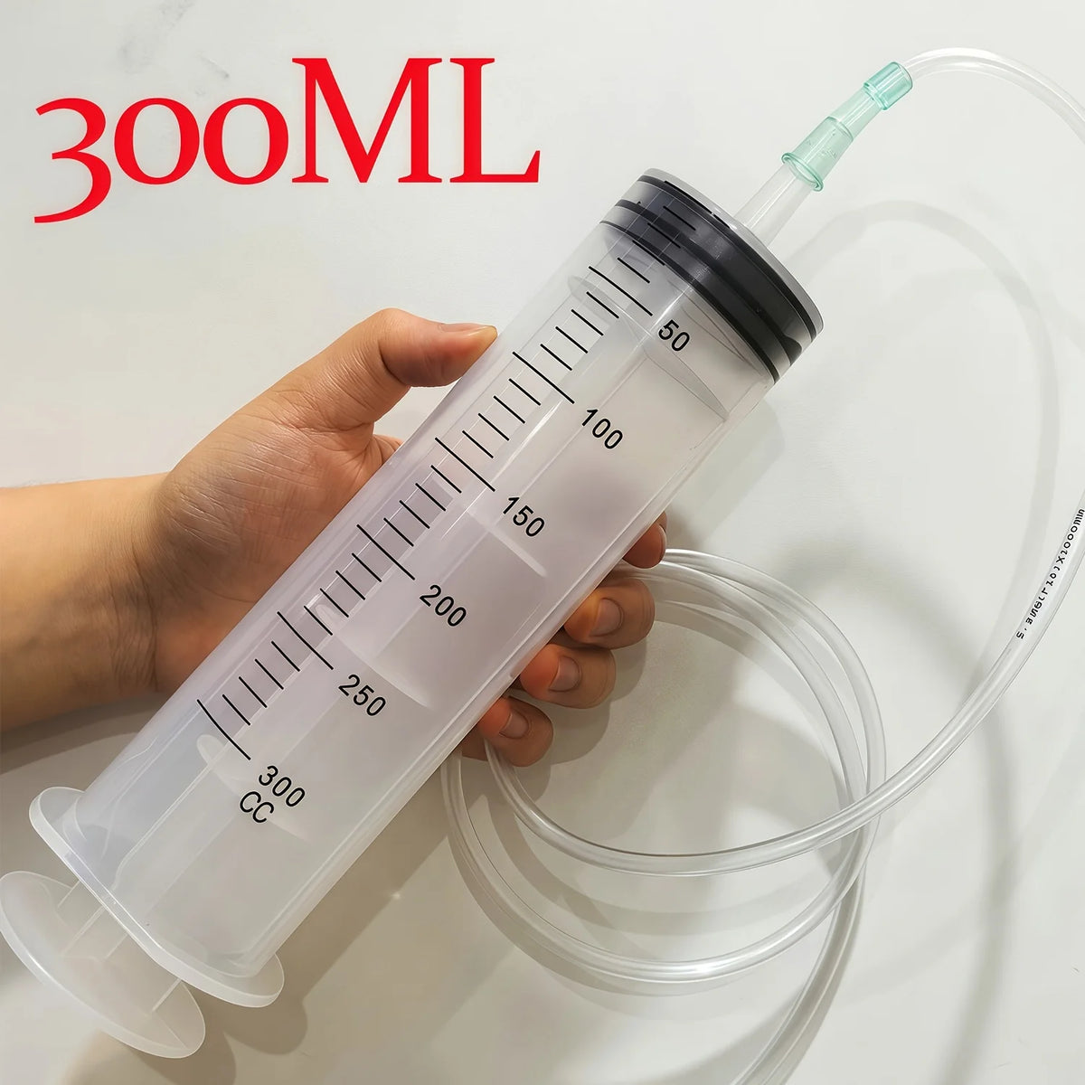 A hand holds a clear plastic syringe measuring 300mL of liquid, demonstrating a pet water bottle refill tool.