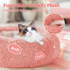 A fluffy pink pet bed with a cat resting on it, emphasizing softness and warmth.