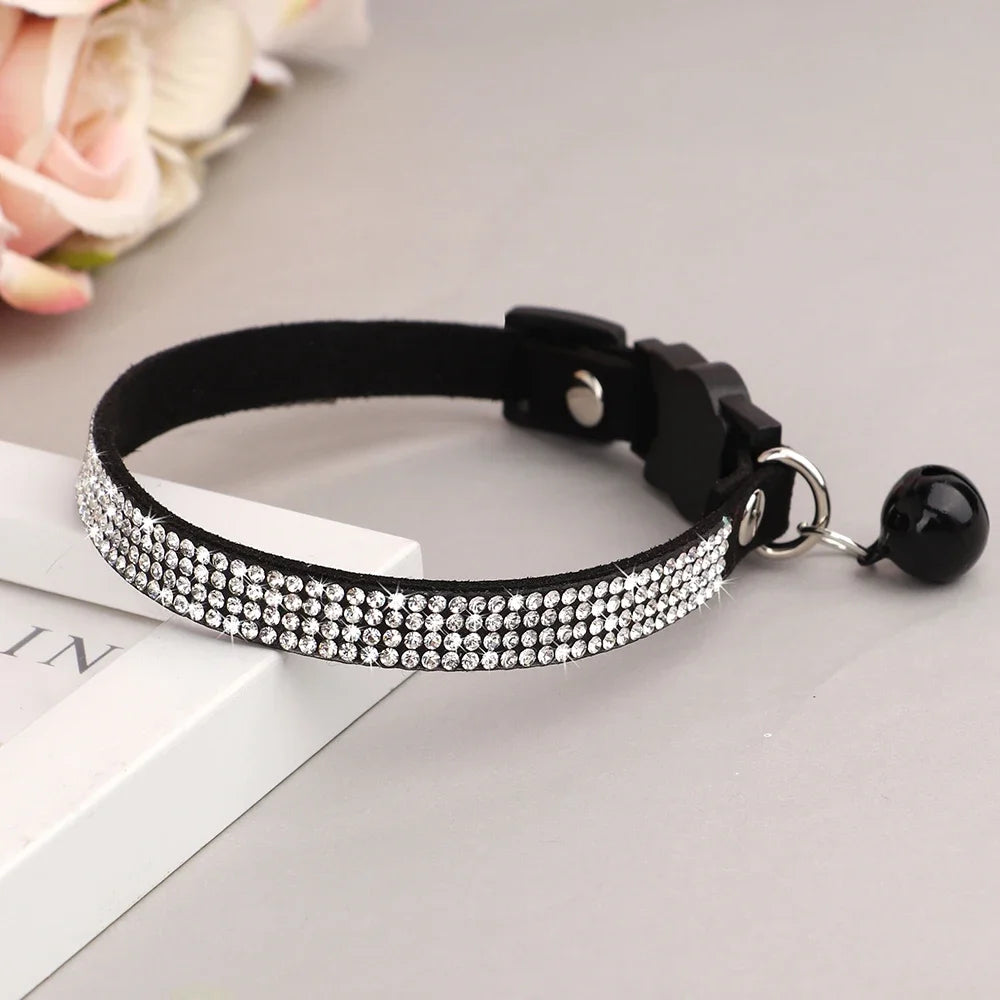 Black collar with a rhinestone chain and safety breakaway buckle resting on a white box.