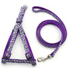 Purple and black patterned adjustable dog harness with a leash shown against a white background.